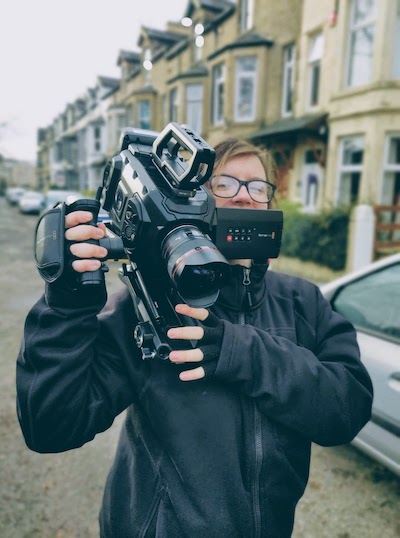 Digital Content Ambassador Rebecca holding video camera in street in Lancaster