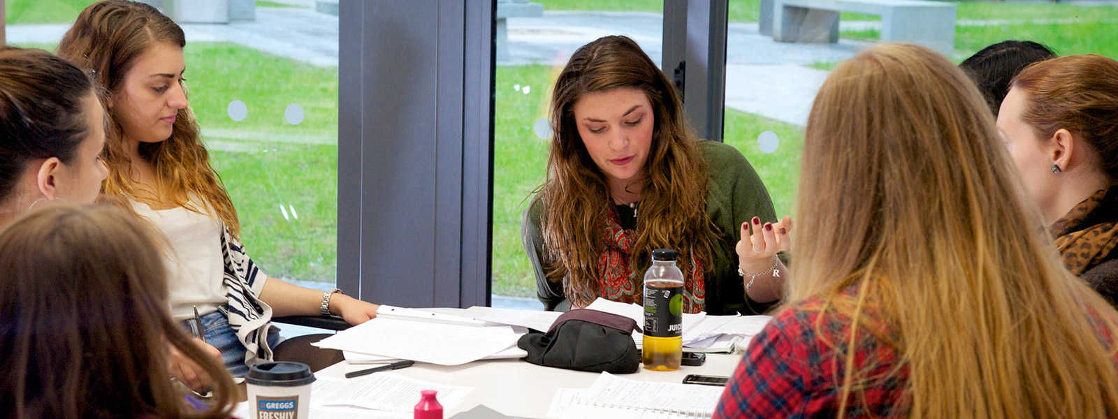 Students talking and working together around a table.