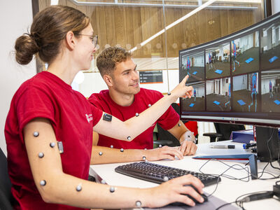 Three students talking in a lecture hall