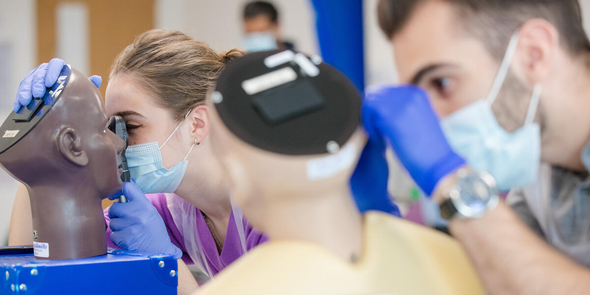 students using simulation manequin to practice medicine
