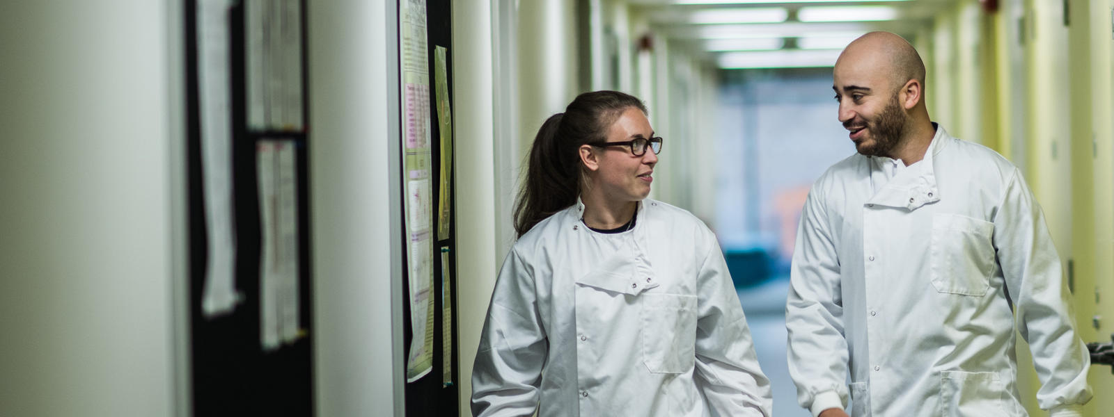 A PhD student discusses work with her supervisor in a laboratory.