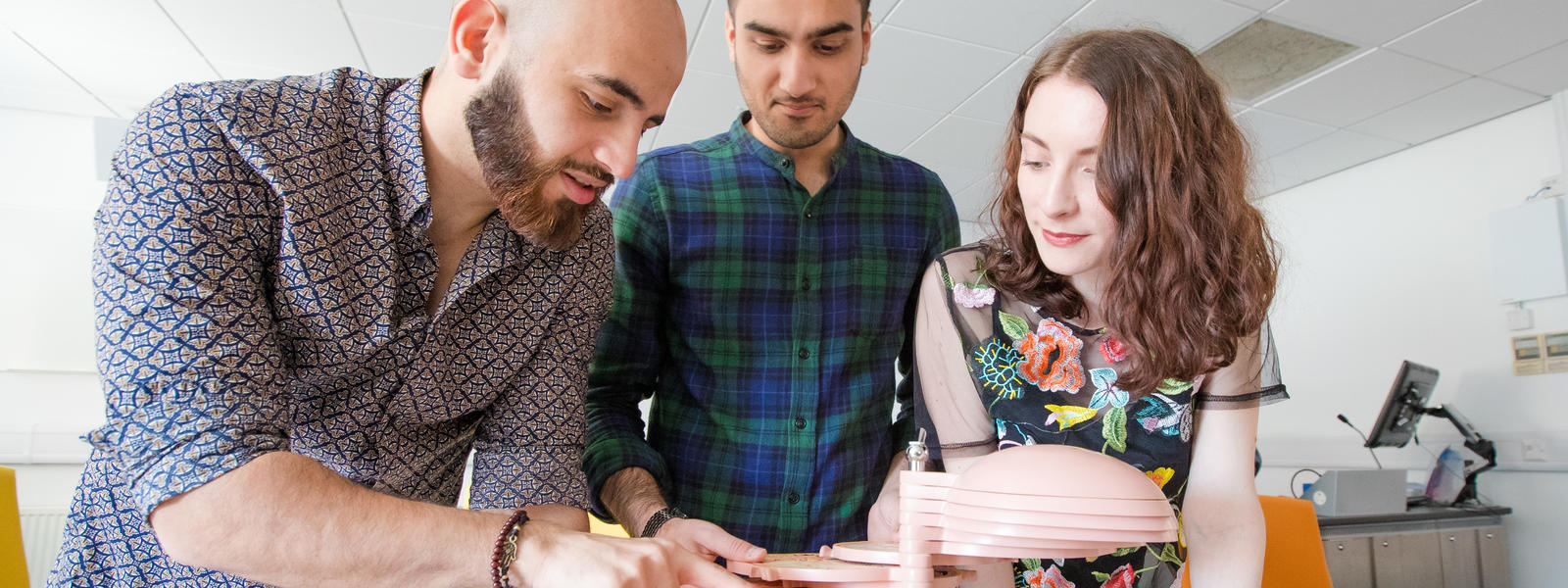 Three students examine an anatomy model