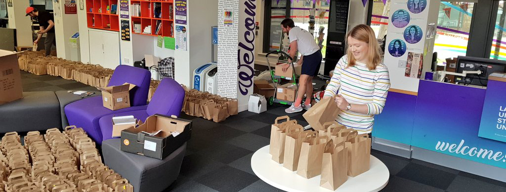 Two people packing bags for the Connecting Kids initiative 