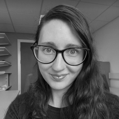 Professional headshot of Alexandra Krendel, a woman with dark hair and glasses, smiling at the camera