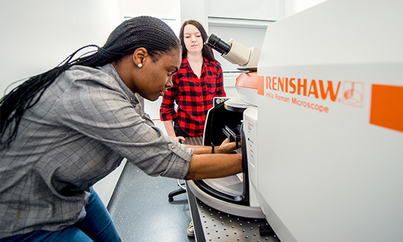 Two students use a Raman microscope