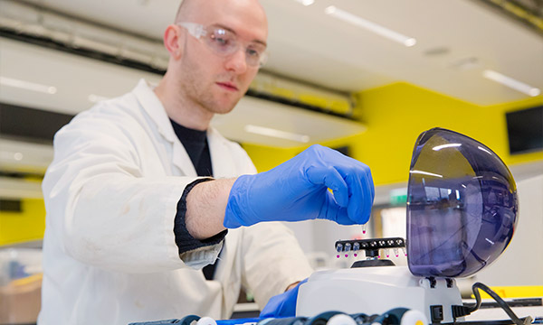A student loads a centrifuge in a laboratory