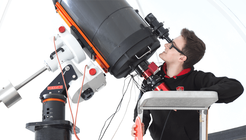 A student looking through the telescope in the Dome