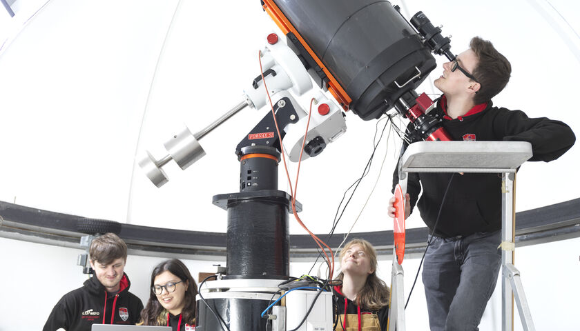 Students using the telescope in the dome