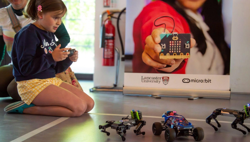 A child playing with a micro:bit robot dog