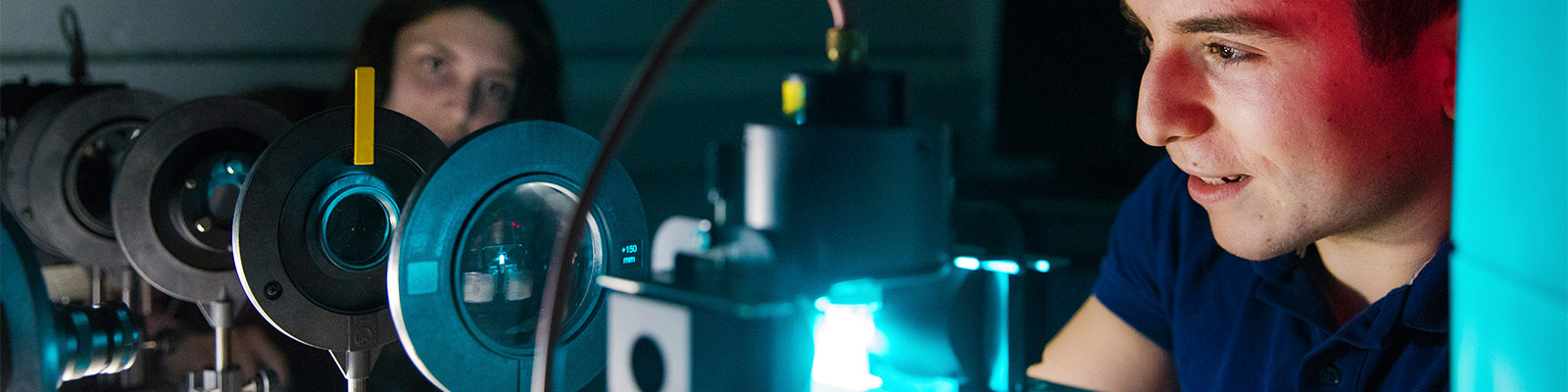 Two students use laser equipment in the Physics Department