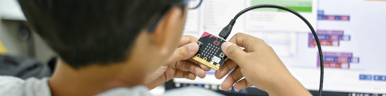 A young child looking at a microbit