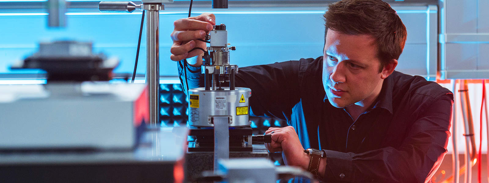 A man adjusts some apparatus in the Physics Isolab