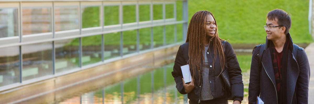 Two students walking outside the Postgraduate Statistics Centre