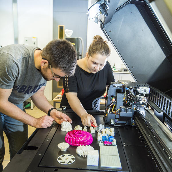 A student and lecturer using a 3d printer
