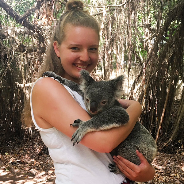 A student holding a koala bear