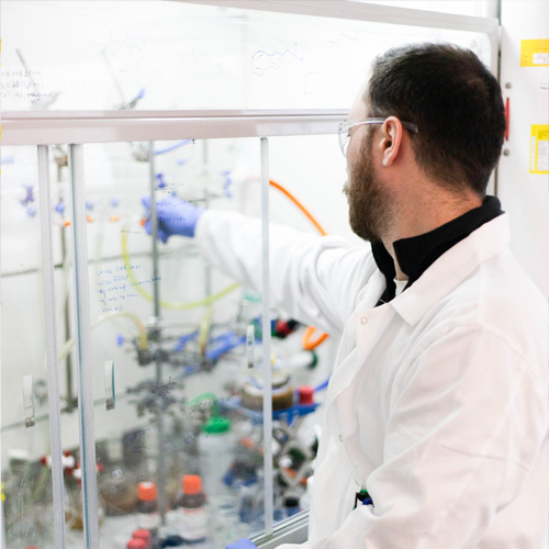 A chemist working inside a fume cupboard