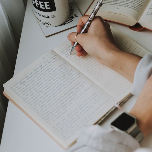 A person writing in a notebook
