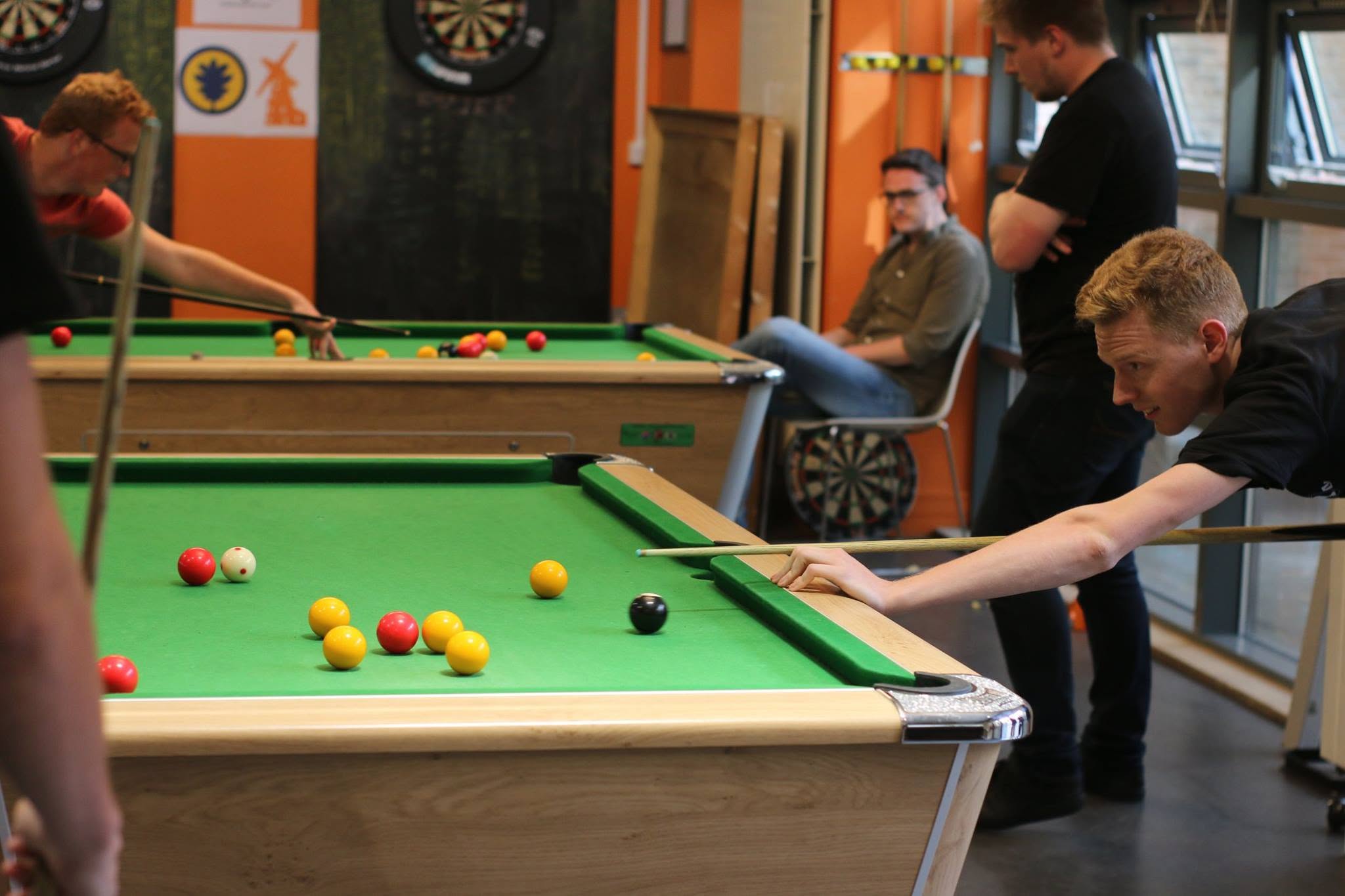 Photo shows person leaning over a pool table