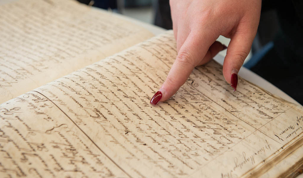 Finger pointing at an old book