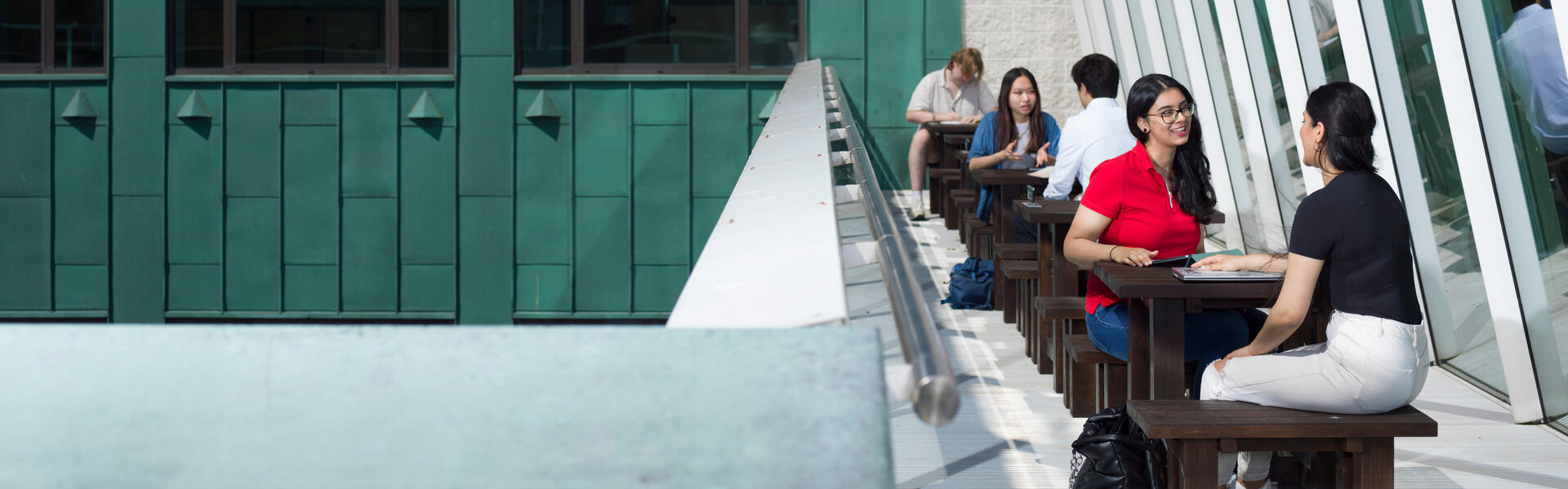 People sit at tables on an outdoor terrace at Lancaster's InfoLab21 buidling