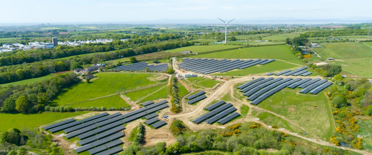 An aerial view of the solar farm and wind turbine.