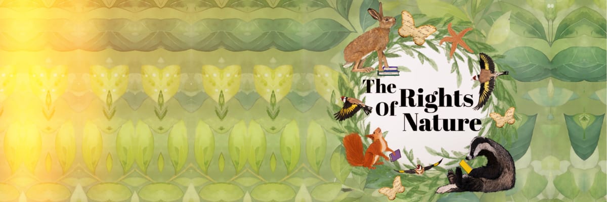 A pile of English Literature books stands on a low table in front of a red sofa.