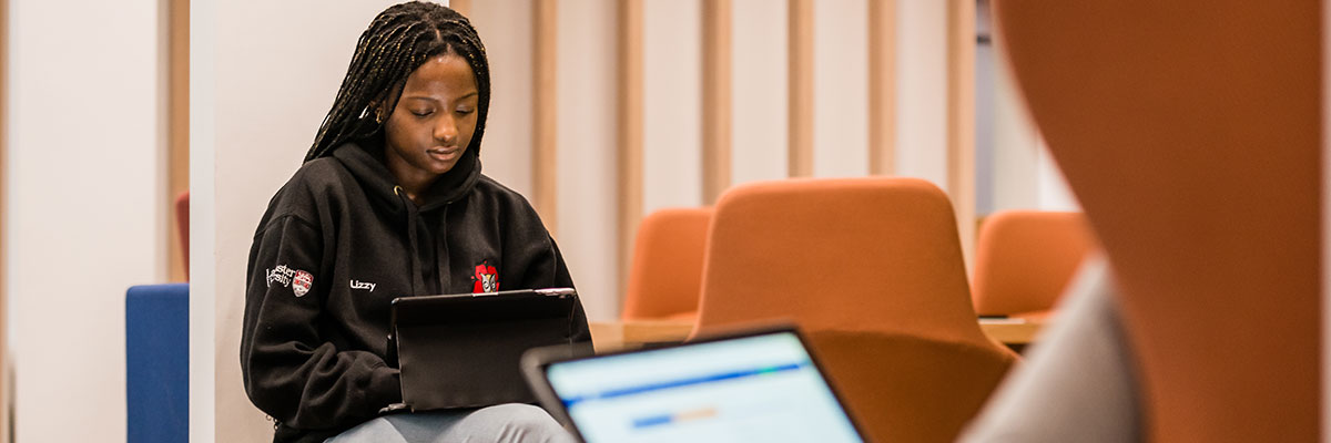 A student in an armchair in the library