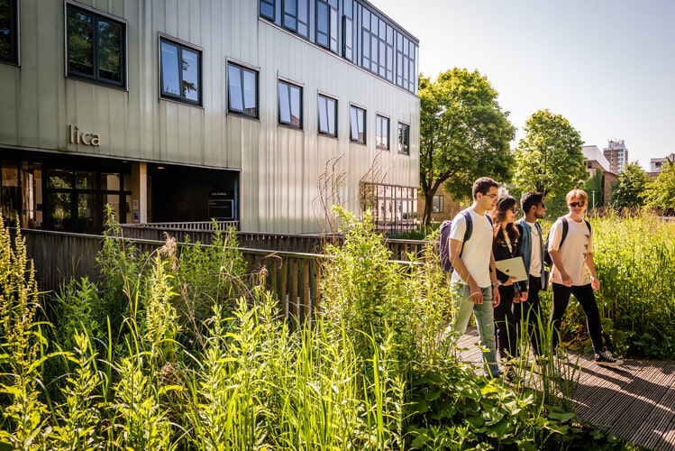 Students walking together beside the lica building