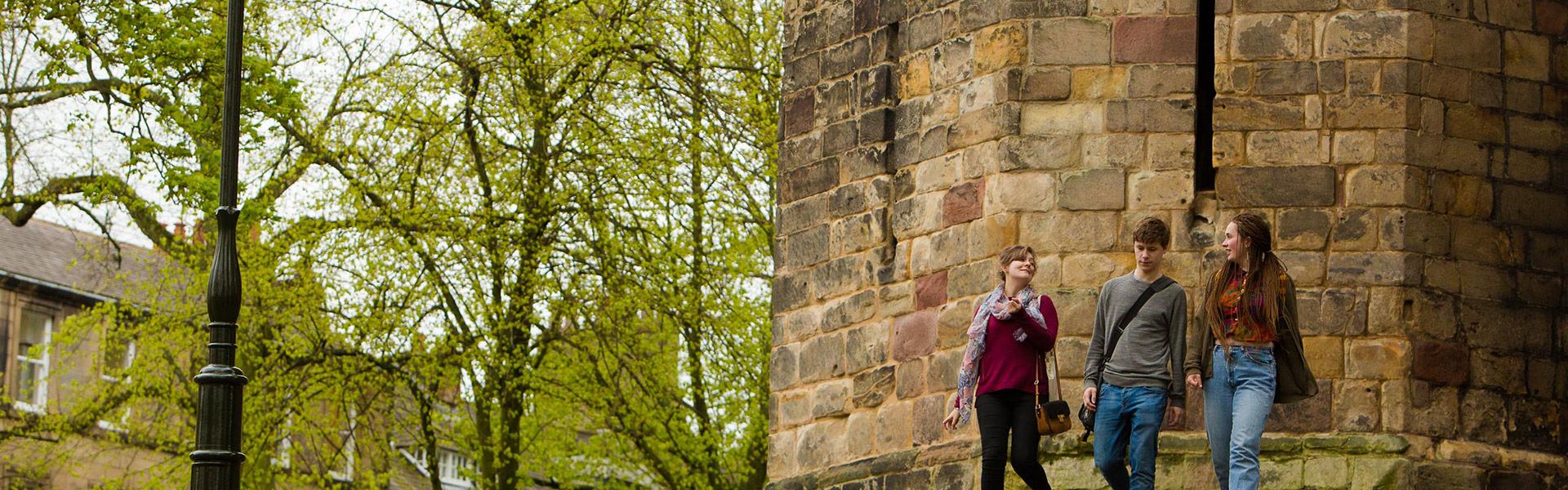 Lancaster University students studying on campus outside in the sunshine