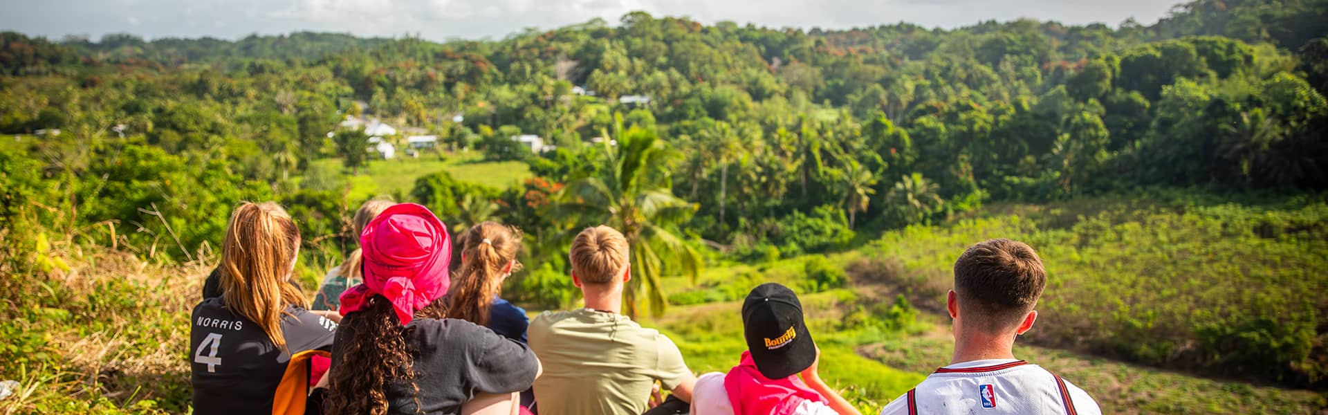 Image of a group of students sat looking out over a viewing point in Fiji