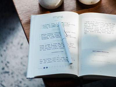 An open notebook with a pen across it.