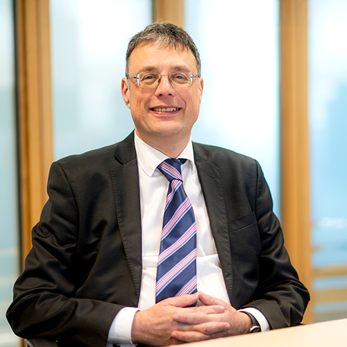 A close-up of Vice-Chancellor Professor Steve Decent wearing a black jacket and striped tie