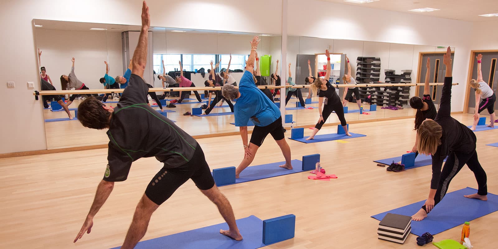 Gym facilities on Campus, people taking part in Yoga.