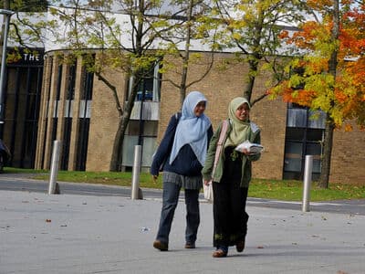 Two muslim women are walking on campus