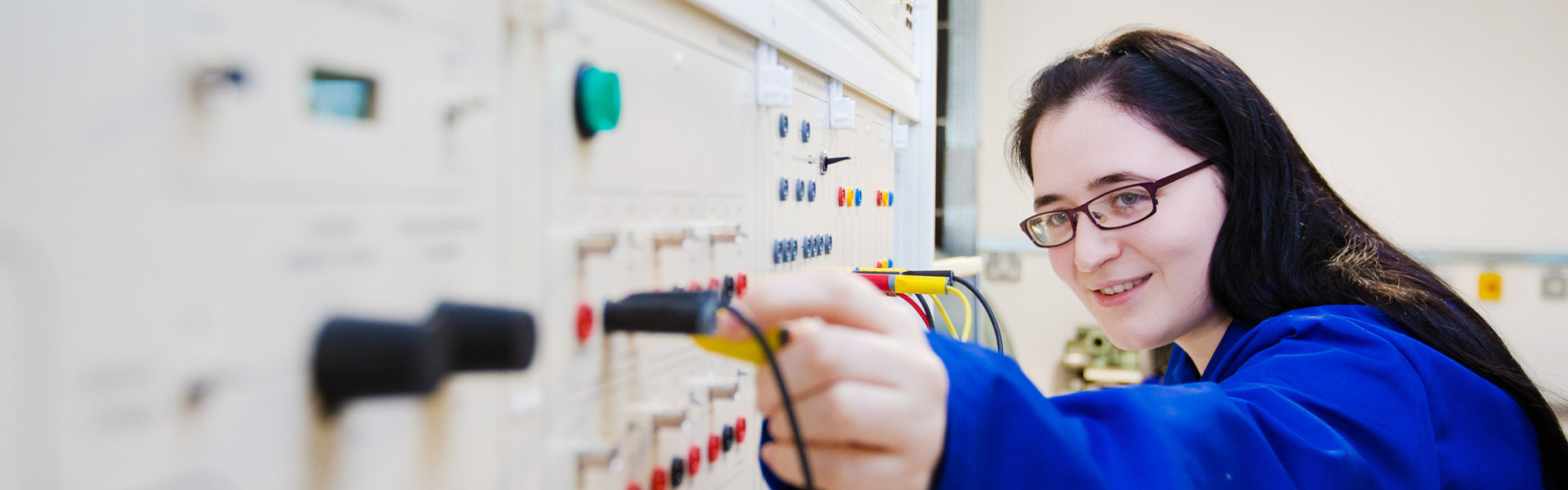 An Engineering student operates some electrical equipment.