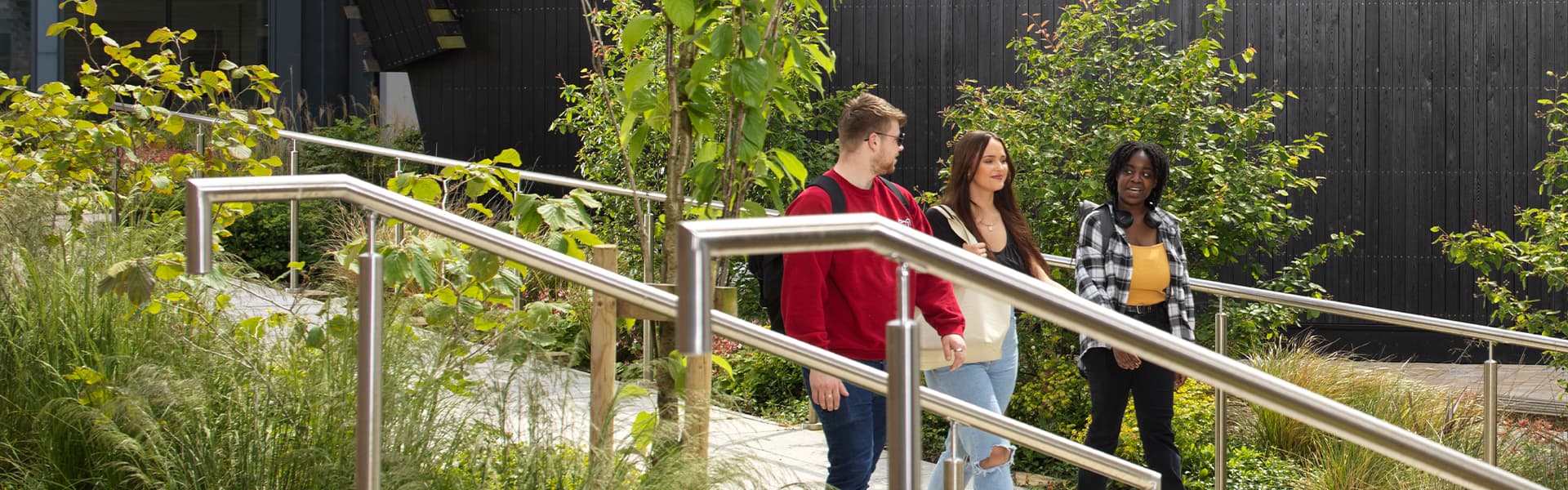 Three students walk past the Margaret Fell Lecture Theatre
