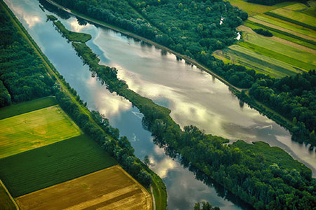 A flooded agricultural landscape beside a managed river channel