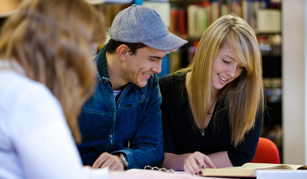 Three students working in the library