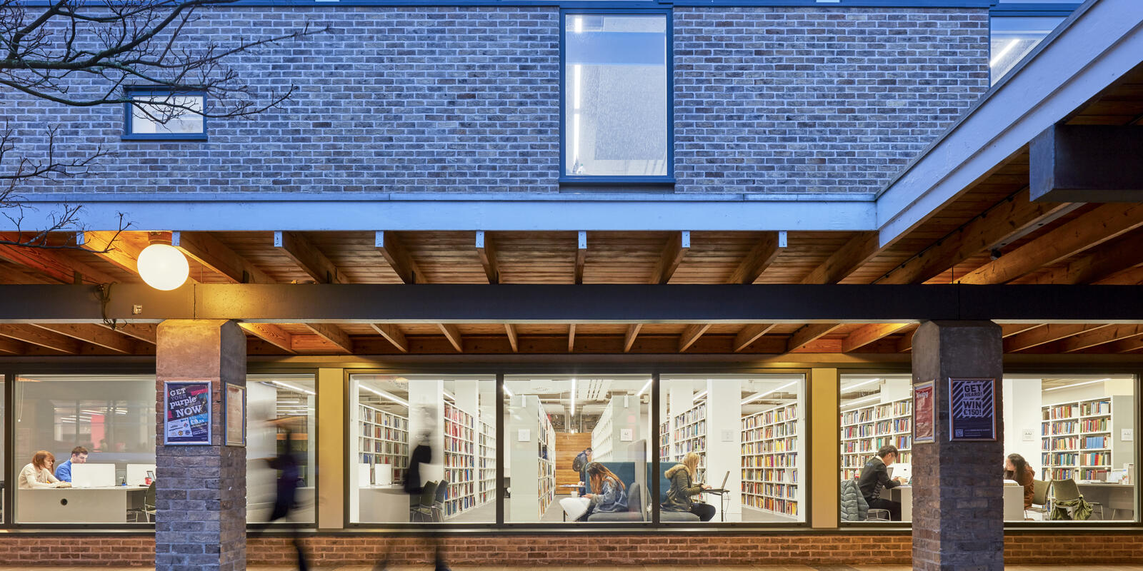 A view through library windows showing  people studying