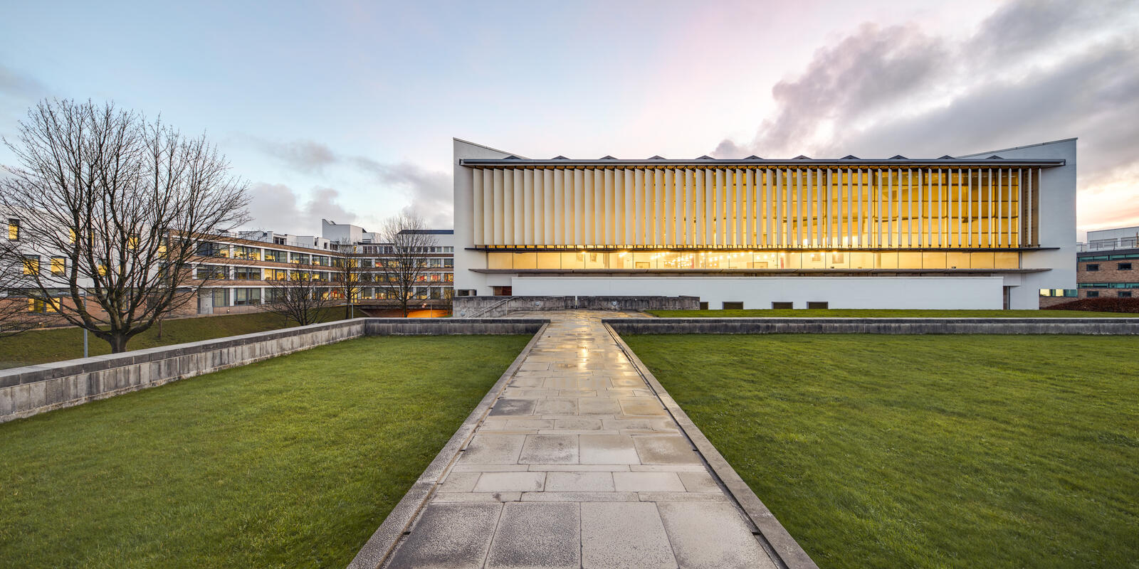 External view of the library at twilight, viewed from the path leading from the Ruskin library. 