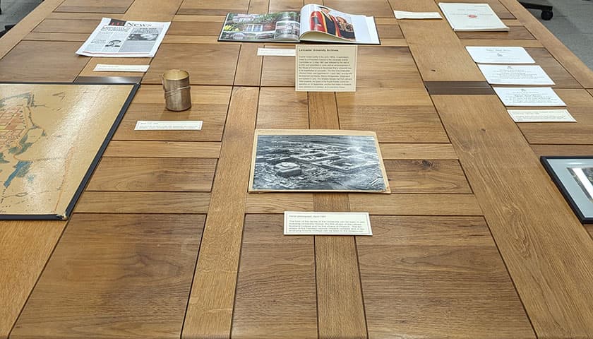 Materials from the University Archives, including photographs and other papers, on a table.