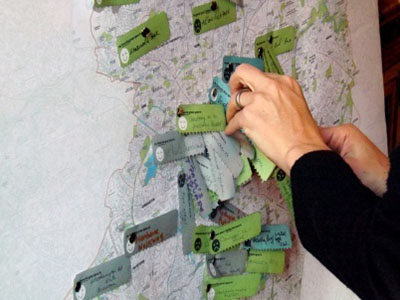 Hands placing pins on a map