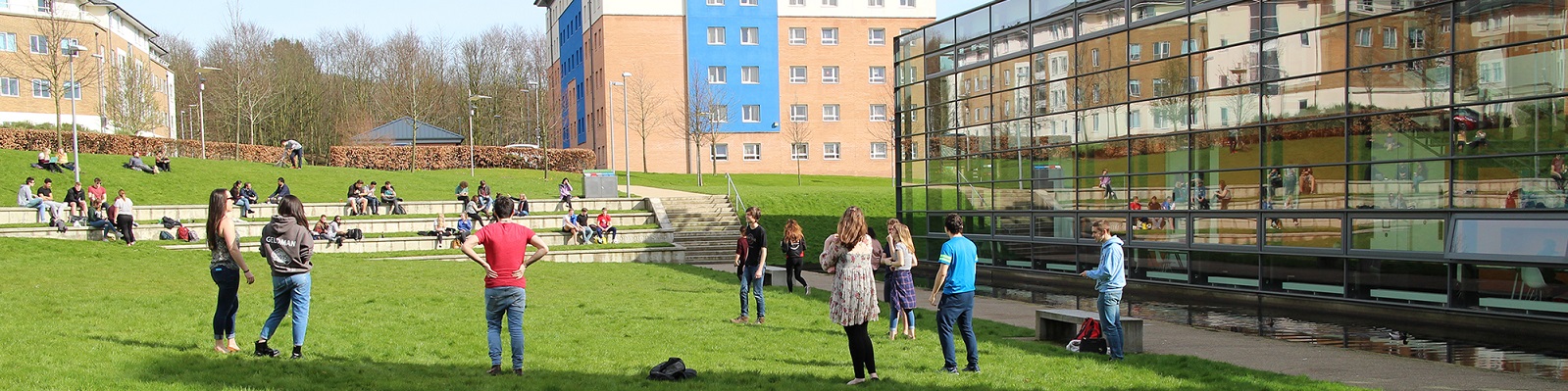 Young people socialising outside on the grass .