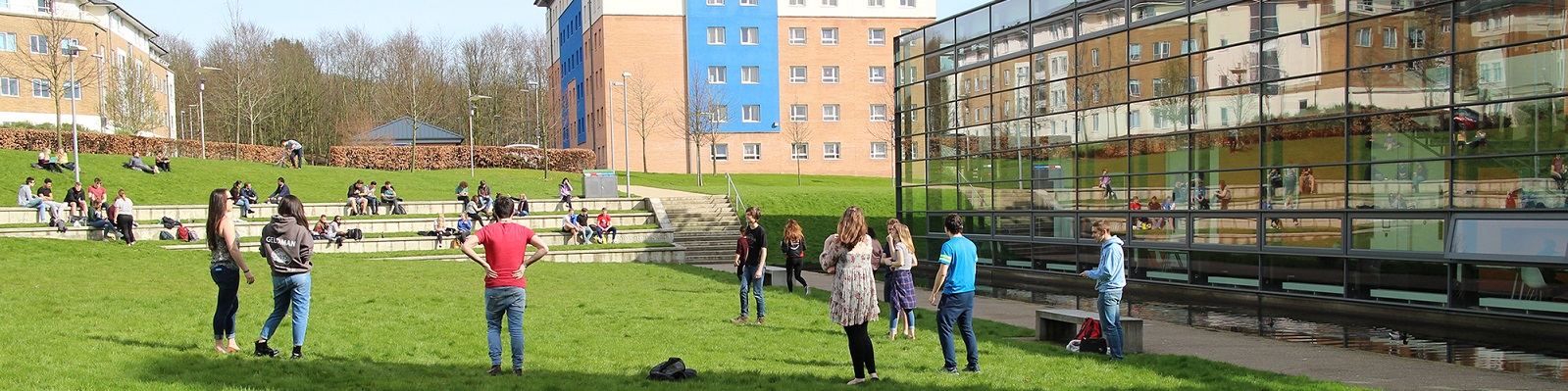 Young people socialising outside on the grass