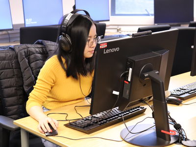 lady in a computer lab with headphones