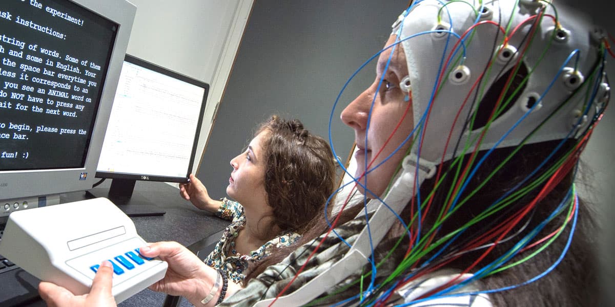 The image shows brain activity during a language task being measured through electroencephalography (EEG)