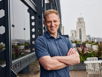 Tom wearing a polo shirt stood at a city viewpoint