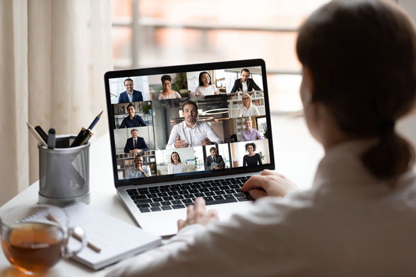 A female looking at a laptop taking part in an online meeting