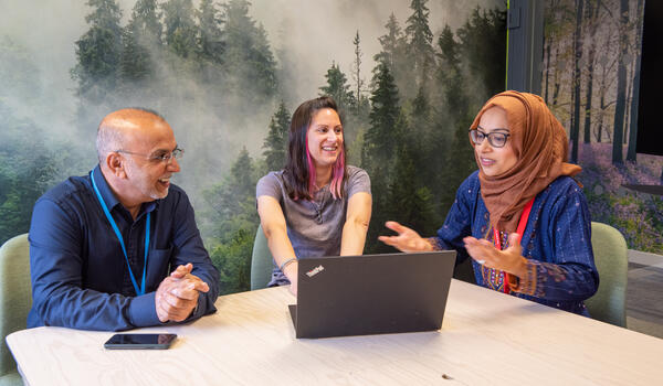 A group of professionals in conversation in a meeting room