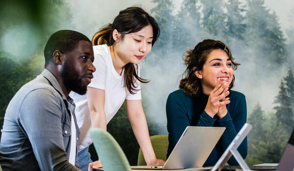 Three students working together with laptops
